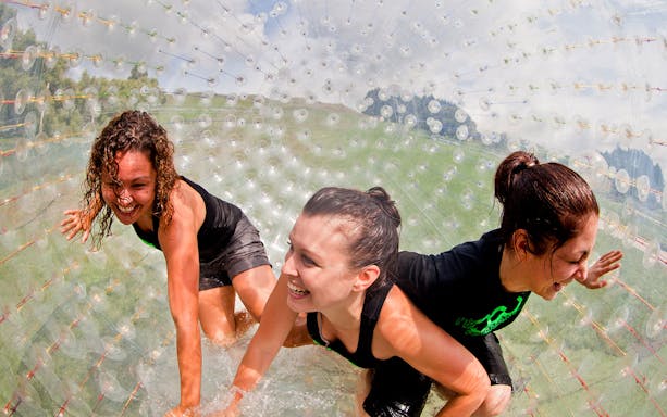 People enjoying ZORB ride at Rotorua, New Zealand, inside a giant inflatable ball.