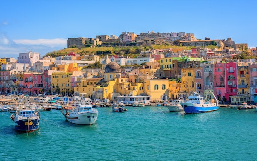 Colorful buildings and boats in the harbor of Procida Island, Italy.