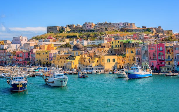 Colorful buildings and boats in the harbor of Procida Island, Italy.