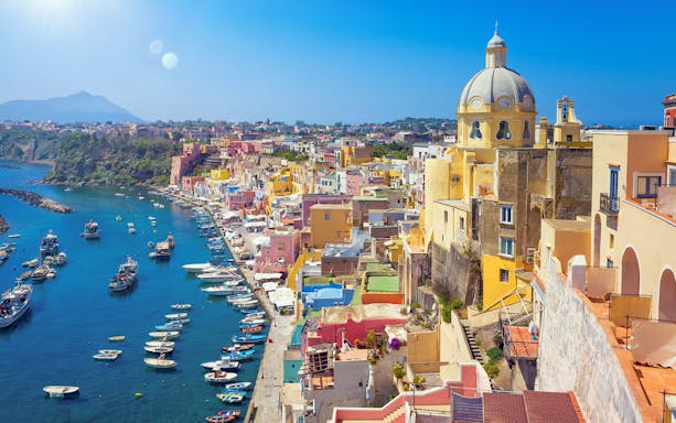 Colorful buildings and boats along the waterfront of Procida Island, Italy.