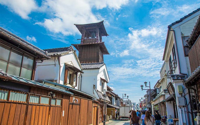 Historic bell tower in Kawagoe, Japan, along a traditional street with visitors.