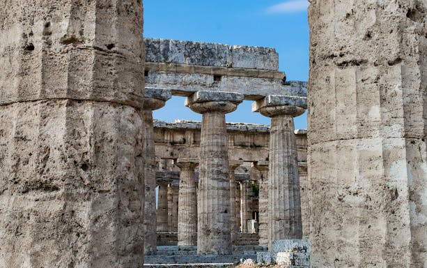 Ancient Greek temple columns in Paestum, Italy, part of a day tour from Naples.