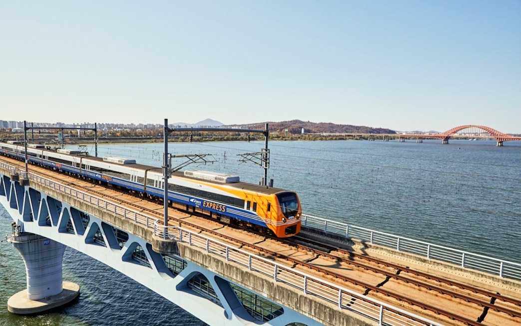 AREX Express train crossing a bridge over water between Incheon Airport and Seoul.