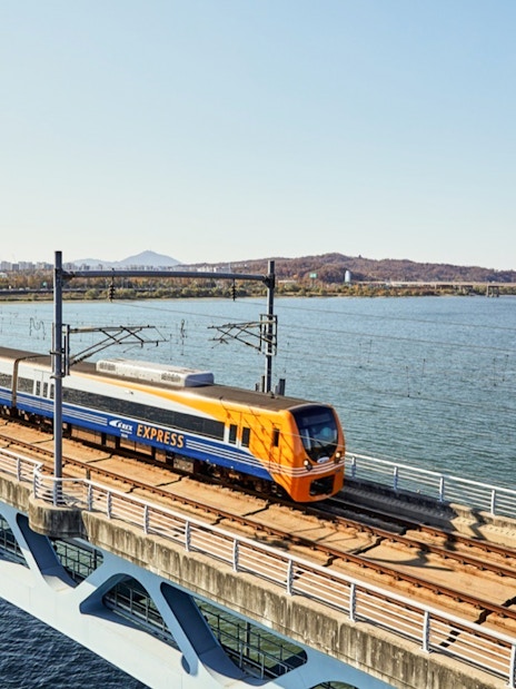AREX Express train crossing a bridge over water between Incheon Airport and Seoul.
