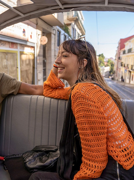 Two people enjoying a tuk-tuk ride along Lisbon's 28 tram route.