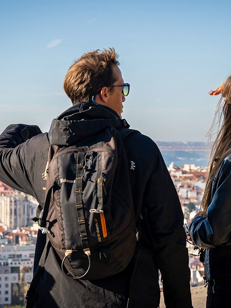 Tourists overlooking Lisbon with the 25 de Abril Bridge in the background.