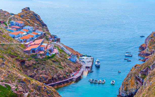 Berlenga Grande Island harbor with boats and colorful houses, Portugal.