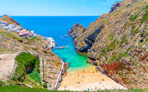 Berlenga Grande Island beach with boats and cliffs, part of Lisbon cave tour.
