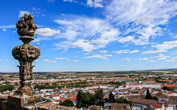 Rooftop view of Évora with historic architecture and countryside, Portugal.