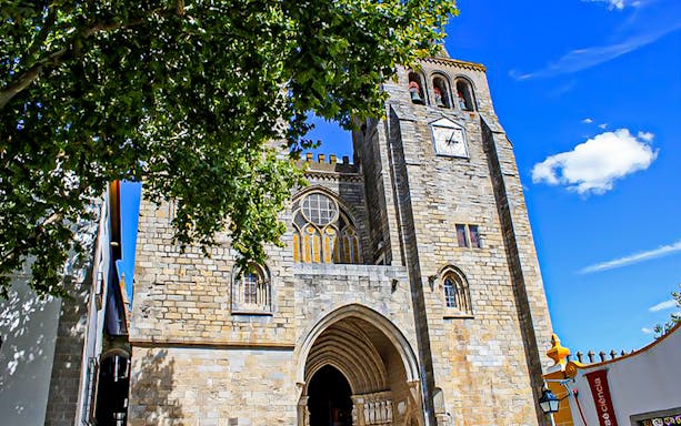 Évora Cathedral facade with clock tower, viewed during a guided tour from Lisbon.
