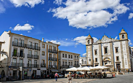 Évora town square with historic church and outdoor café, Portugal.