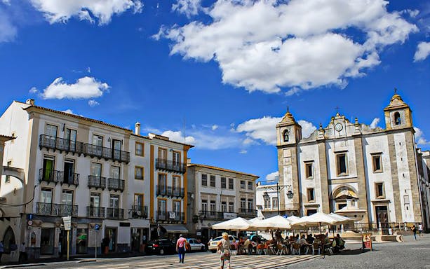 Évora town square with historic church and outdoor café, Portugal.