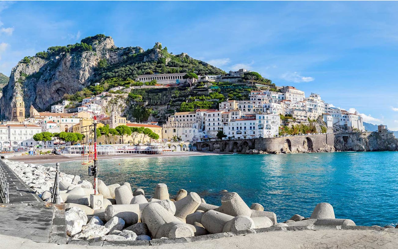 Amalfi Coastline with colorful buildings and cliffs viewed from the sea.