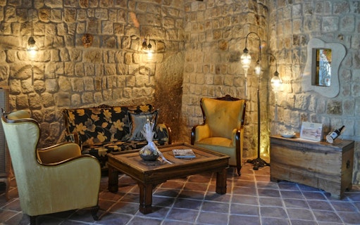 Cave hotel lounge with stone walls and vintage furniture in Cappadocia.