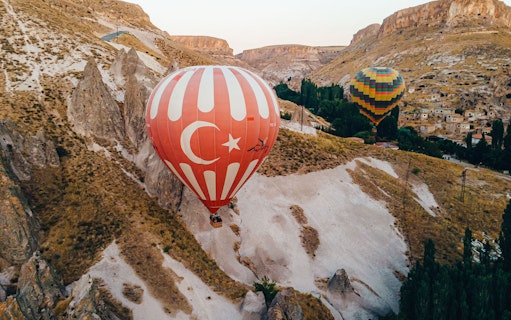 Hot air balloons over Cappadocia's unique rock formations during a 2-day tour from Istanbul.