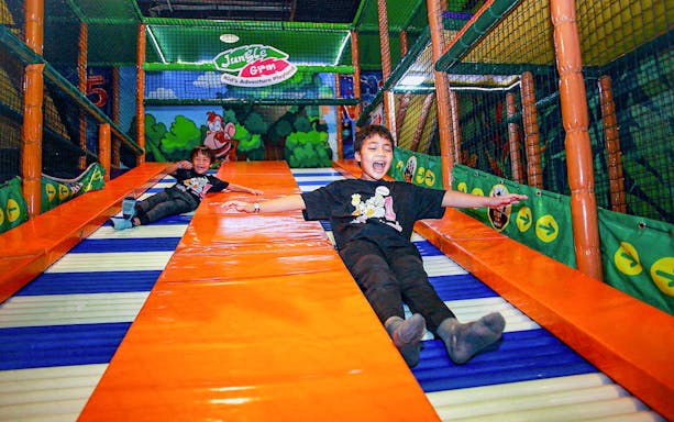 Children sliding at Jungle Gym, Kuala Lumpur indoor playground.