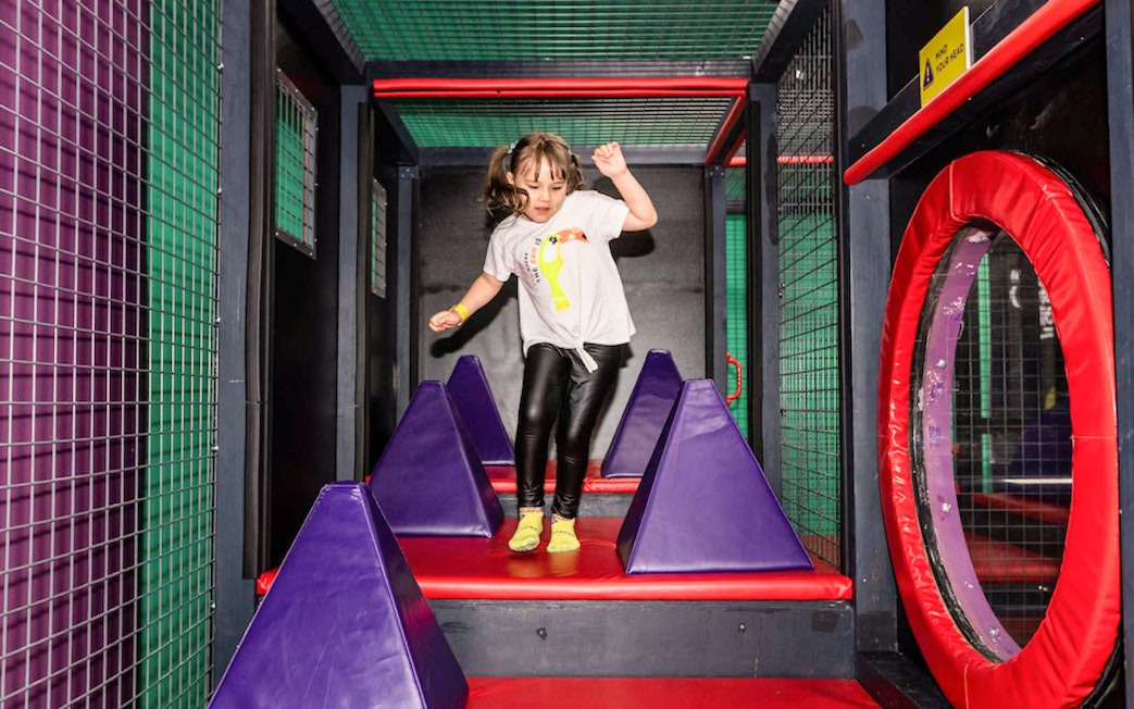 Child navigating obstacle course at SuperPark Malaysia.