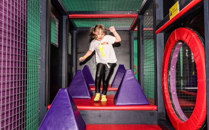 Child navigating obstacle course at SuperPark Malaysia.