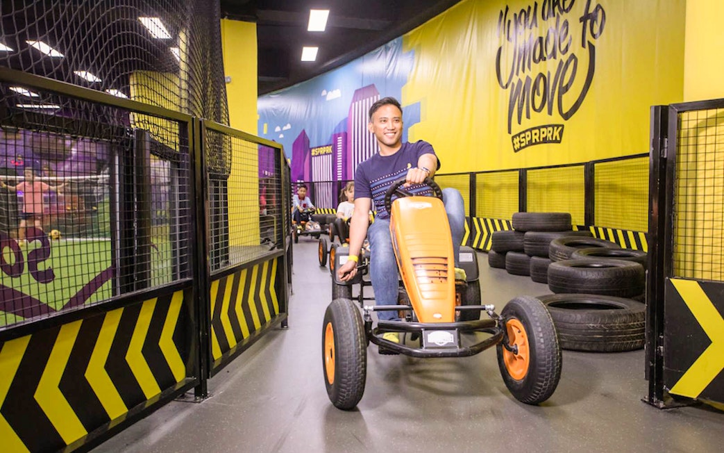 Man driving go-kart at Super Park, Malaysia indoor track.