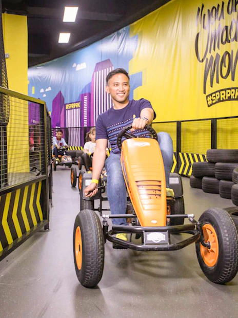 Myr Language Man driving go-kart at Super Park, Malaysia indoor track.