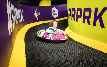 Girl sliding on colorful air tube at SuperPark, Malaysia indoor playground.