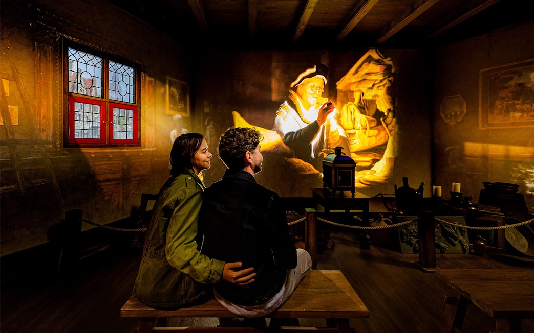 Tourists watching Rembrandt projection at Rembrandts Amsterdam Experience.
