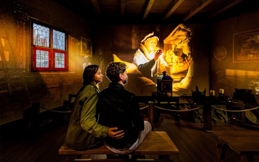 Tourists watching Rembrandt projection at Rembrandts Amsterdam Experience.