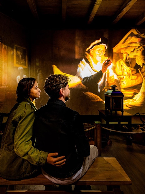 Tourists watching Rembrandt projection at Rembrandts Amsterdam Experience.