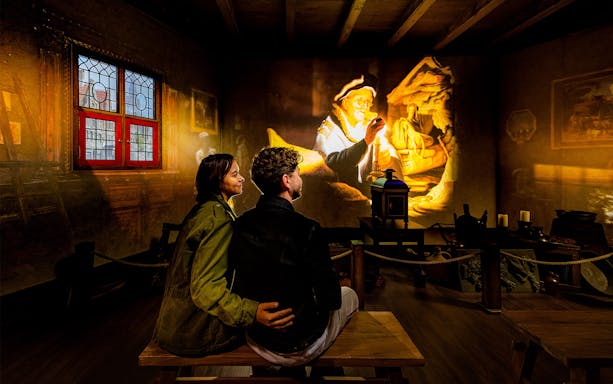 Tourists watching Rembrandt projection at Rembrandts Amsterdam Experience.