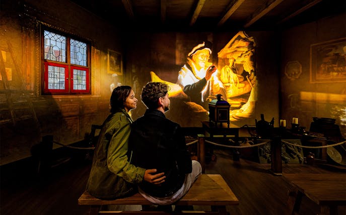 Tourists watching Rembrandt projection at Rembrandts Amsterdam Experience.