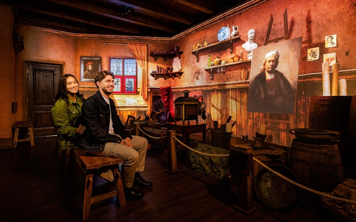 Couple enjoying Rembrandts Amsterdam Experience in a recreated artist's studio.