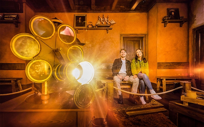 Visitors enjoying Rembrandts Amsterdam Experience with historical decor and lighting effects.