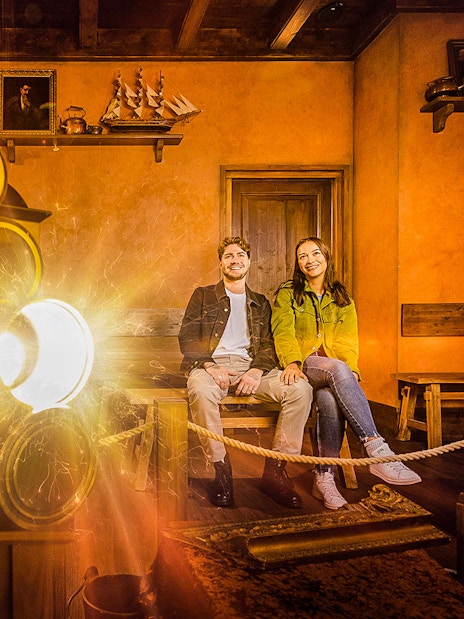 Visitors enjoying Rembrandts Amsterdam Experience with historical decor and lighting effects.