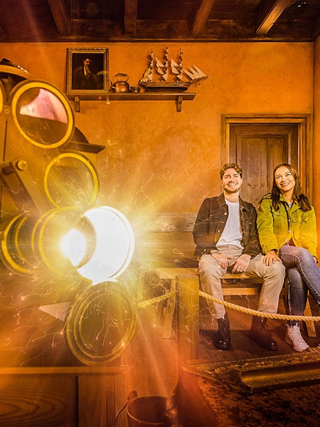 Visitors enjoying Rembrandts Amsterdam Experience with historical decor and lighting effects.