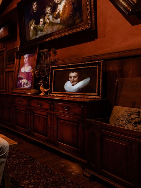 Tourists enjoying Rembrandt's Amsterdam Experience surrounded by classic paintings.