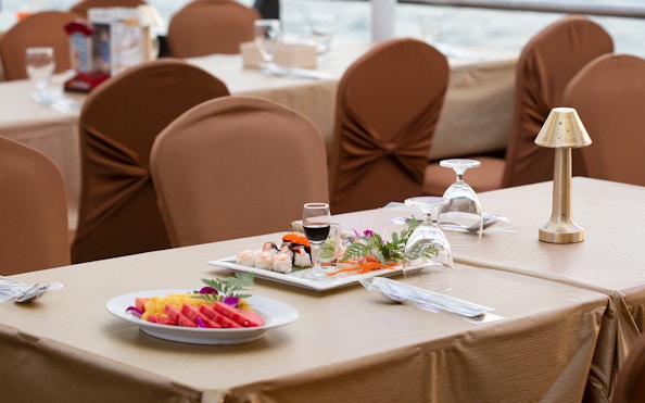 Dinner setup with sushi and fruit on Chao Phraya Cruise, Bangkok.