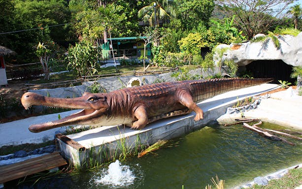 Crocodile statue at Crocodile Adventureland Langkawi near a pond.