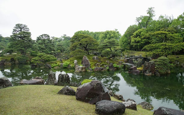 Nijo Castle garden with pond and stone bridge in Kyoto, Japan.