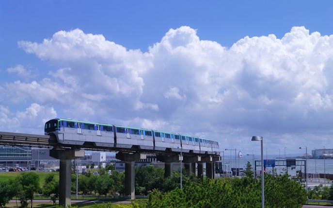 Monorail traveling from Haneda Airport to Tokyo under a blue sky.