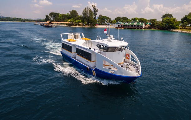 Ferry cruising near St John's Island, Singapore, with lush greenery in the background.