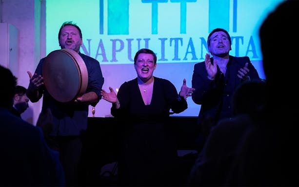 Performers singing at a traditional Neapolitan music concert in Naples.