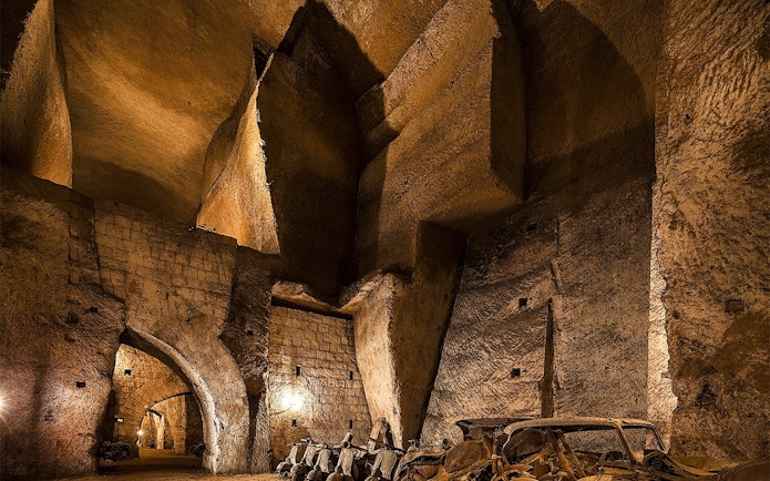 Bourbon Tunnel interior with vintage cars and stone arches, Naples guided tour.