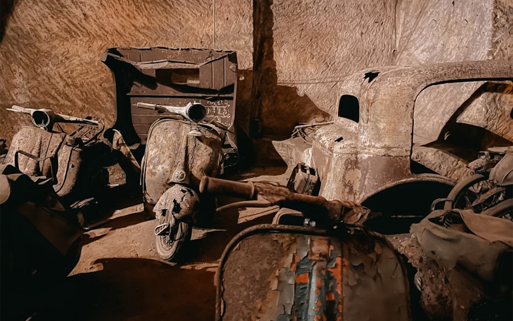 Vintage scooters and car remnants in Bourbon Tunnel, Naples.
