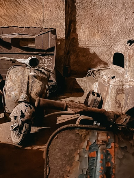 Vintage scooters and car remnants in Bourbon Tunnel, Naples.