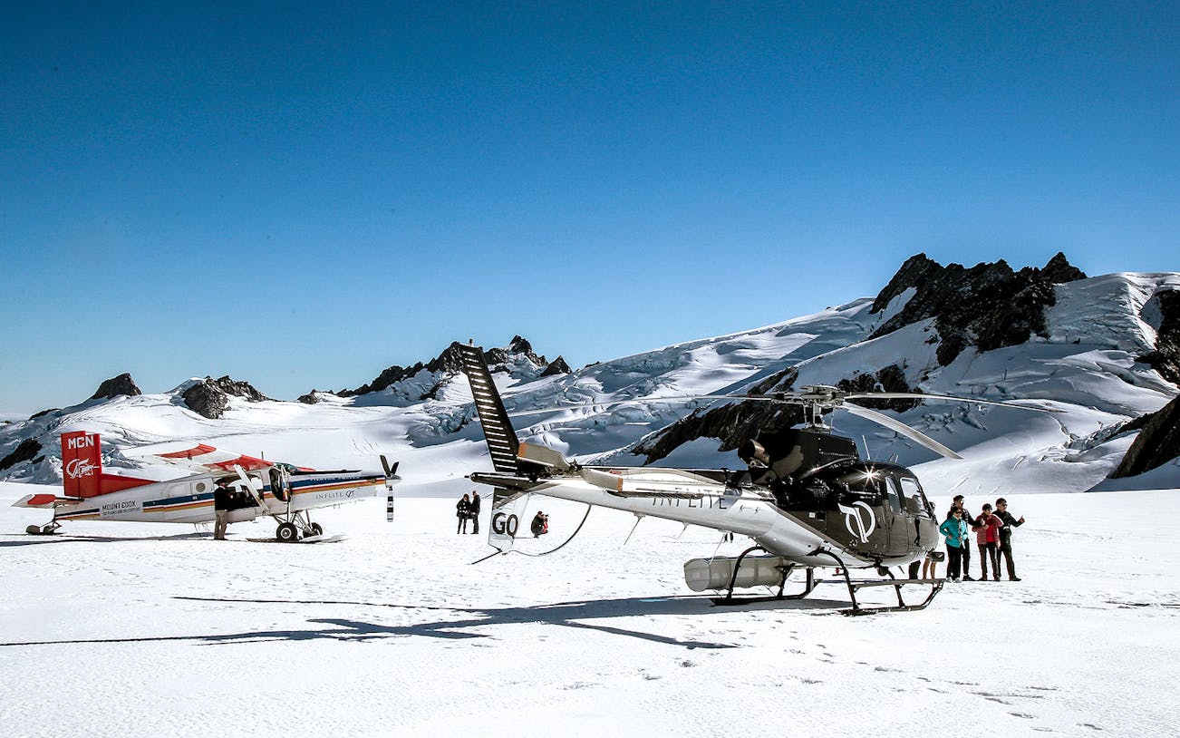 Skiplane and helicopter on snowy alpine landscape with tourists, Ultimate Alpine Experience.
