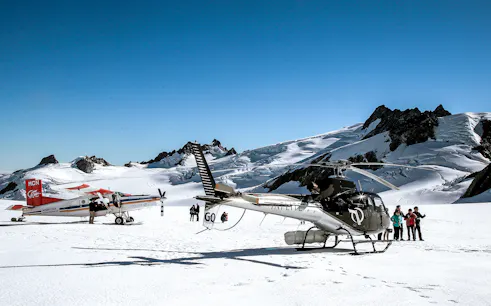 Skiplane and helicopter on snowy alpine landscape with tourists, Ultimate Alpine Experience.
