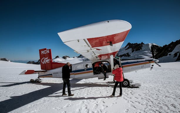Helicopter passengers on snowy glacier during 45-minute flight tour.