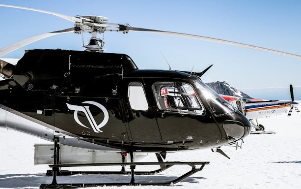 Helicopter and ski plane on snowy glacier during 45-minute flight tour.