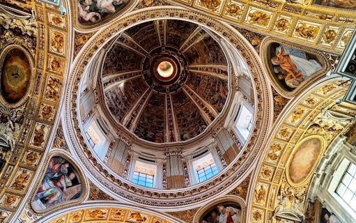 Interior dome of Santa Maria Maggiore Basilica with detailed frescoes and ornate gold accents.