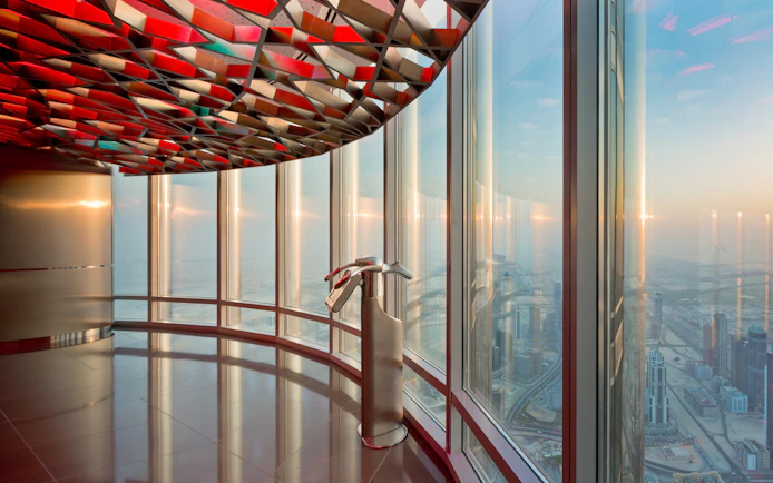 Burj Khalifa observation deck view of Dubai skyline at sunset.